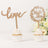 Wooden cupcake toppers "love" and "Mr & Mrs" on white cupcakes.