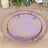 Floral patterned dinner plates in pink and gold on a wooden table.