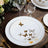 Elegant white plate with gold butterfly design, set on a wooden table.