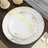 Elegant floral dinner plates with gold accents on a rustic wooden table.