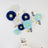 Decorative paper flowers in blue, white, and gold with butterflies on a wall.