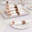 White napkins with brown bands arranged on a decorative platter and plate.