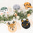 Colorful animal-themed plates arranged on a table with greenery and floral accents.
