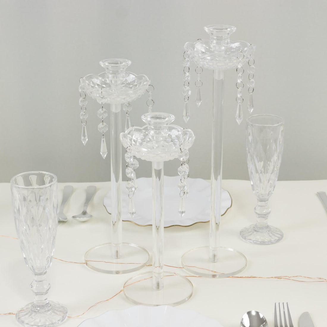 Crystal candle holders with hanging beads on a dining table.