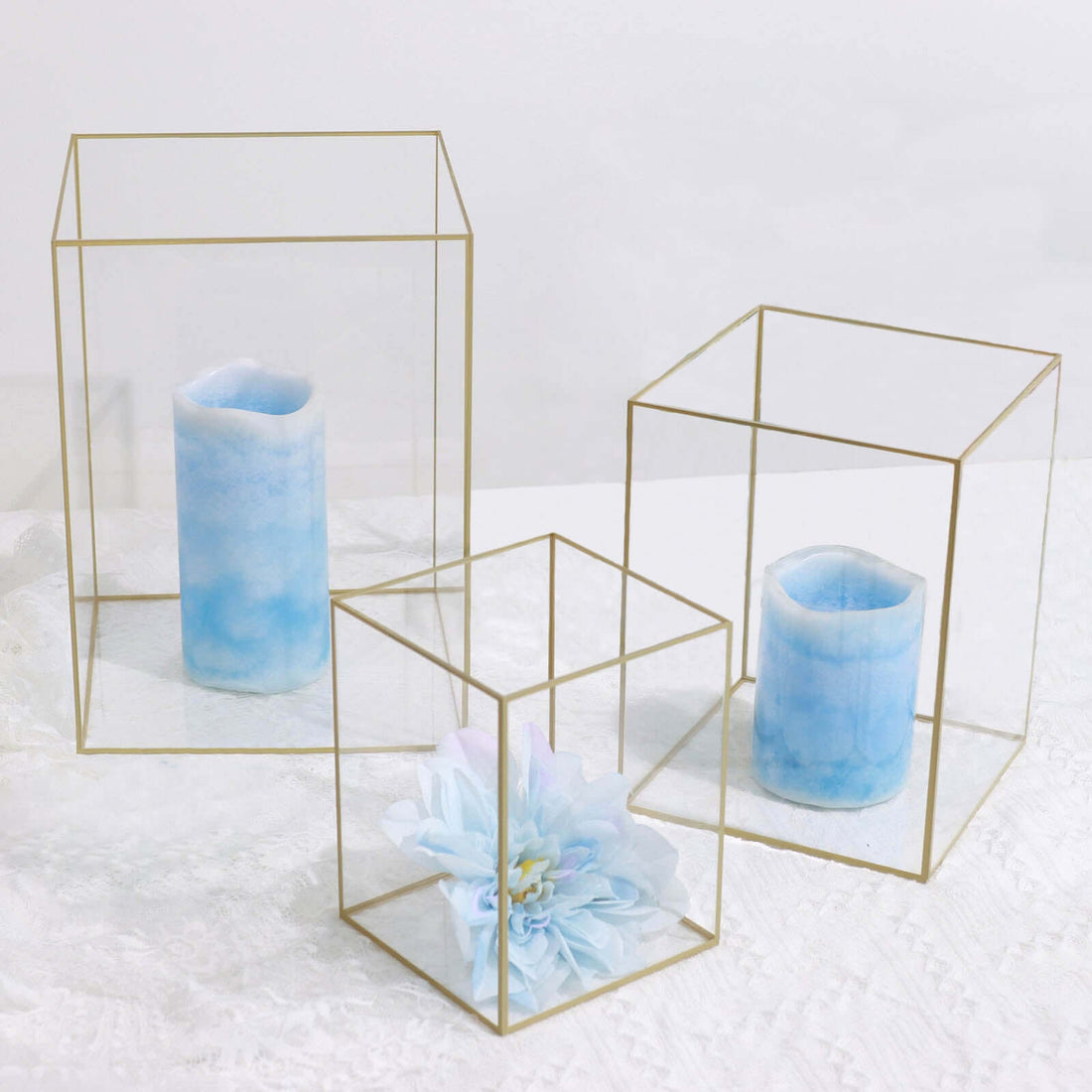 Geometric glass candle holders with blue candles and flowers