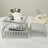 Decorative mirrored cake stands stacked with cakes and flowers on a table.