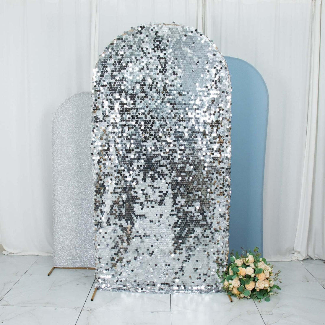 Sequin backdrop in silver tones with soft curves and floral arrangement