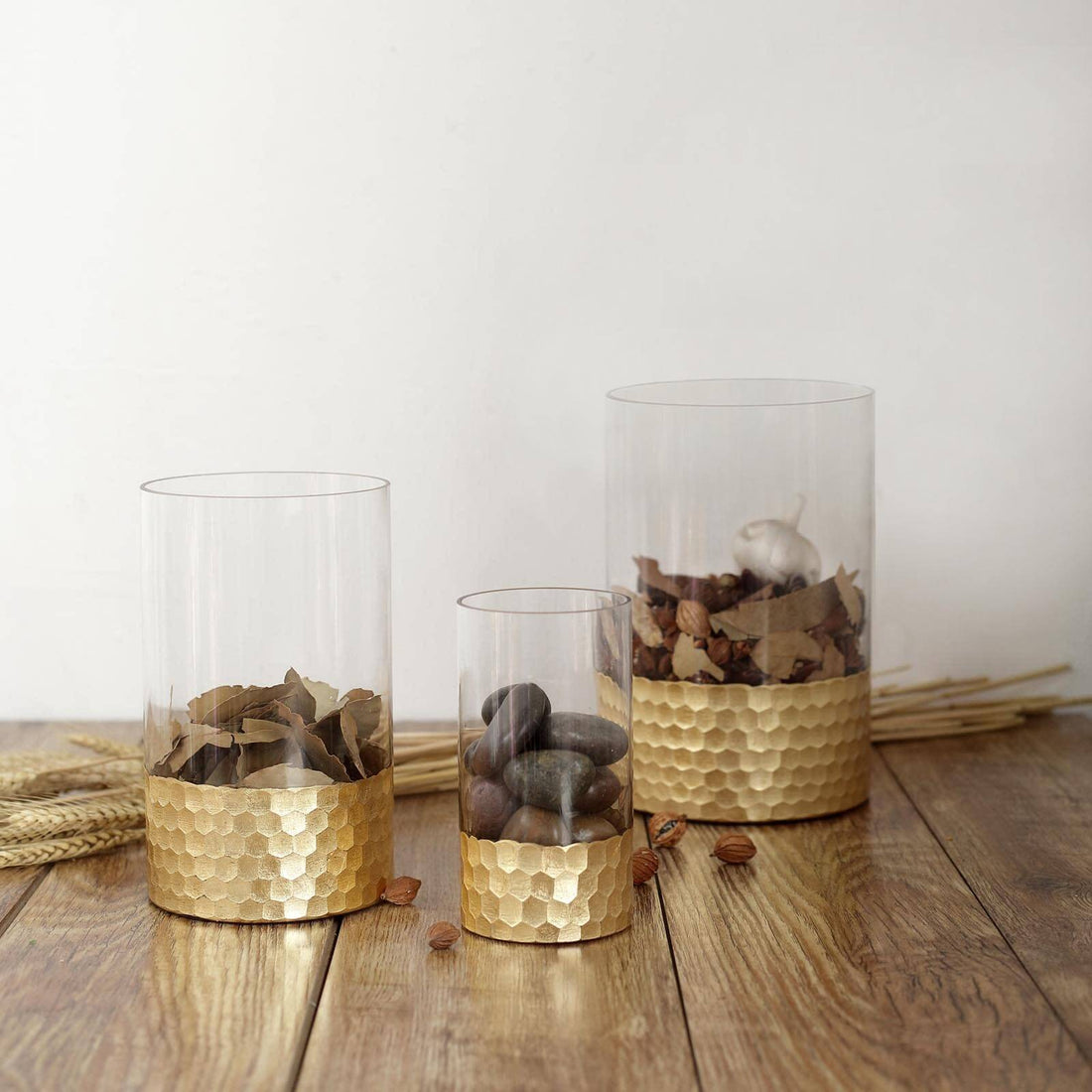 Decorative glass vases with gold honeycomb bases filled with natural elements