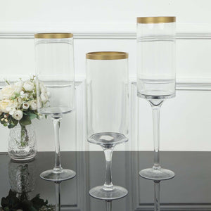 Elegant glass vases with gold rims on a reflective surface.