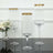 Elegant glass vases with gold rims on a reflective surface.