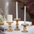 Elegant glass candle holders with white candles and a lit pillar candle.