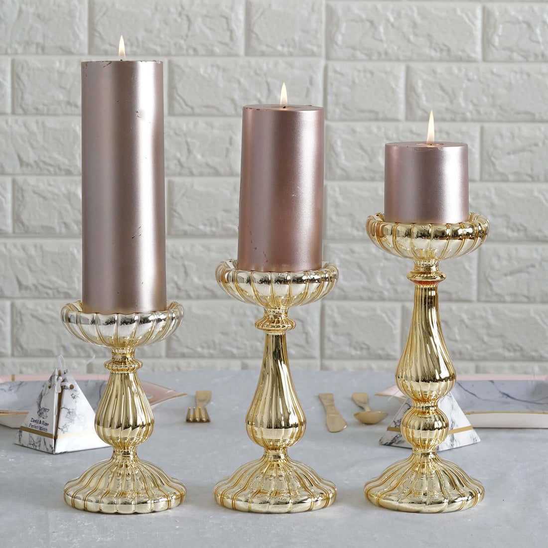 Elegant gold candle holders with pink candles, styled for a chic decor setting.