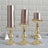 Elegant gold candle holders with pink candles, styled for a chic decor setting.