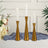 Gold candle holders with white candles and floral arrangement in a stylish setting.