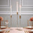 Elegant gold candle holders with white candles set on a table for a dining scene.