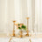 Elegant gold candle holders with tall white candles on a dining table.