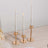 Elegant gold candle holders with white taper candles on a wooden surface.