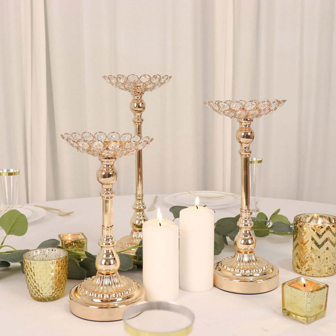 Elegant gold candle holders with crystal accents on a table setting.