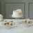 Elegant cake and cupcakes displayed on clear glass stands.