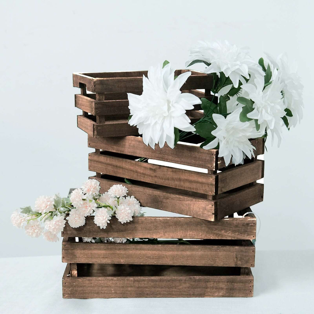 Wooden flower crates with white and pink flowers arranged decoratively.