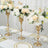 Elegant floral centerpiece arrangements in gold vases on a decorated dining table.