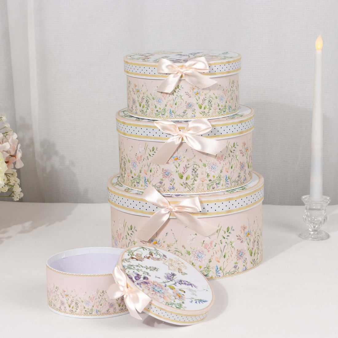 Decorative floral gift boxes with bows stacked on a table.