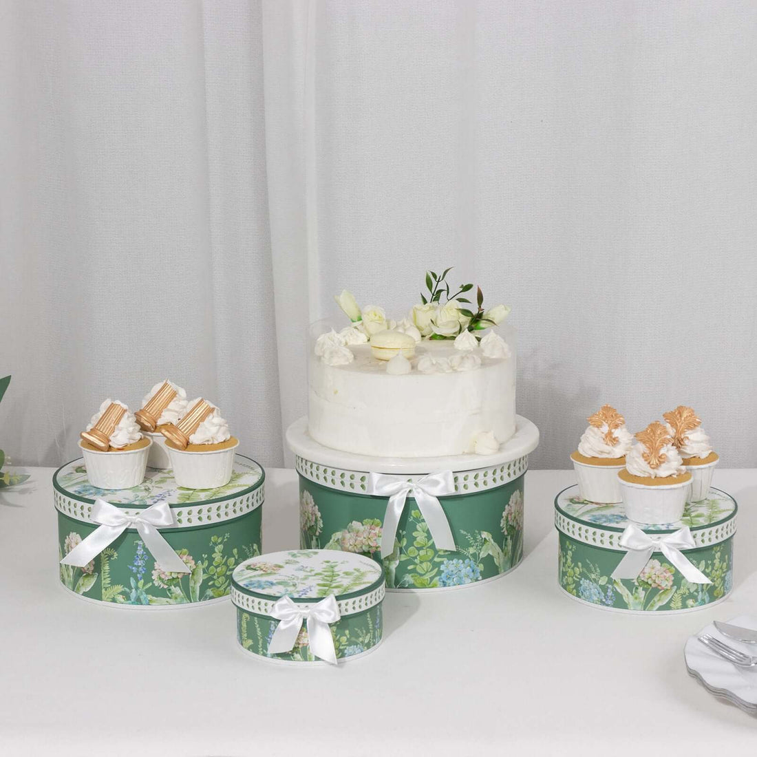 Decorative cake and dessert boxes with floral designs on a white backdrop.