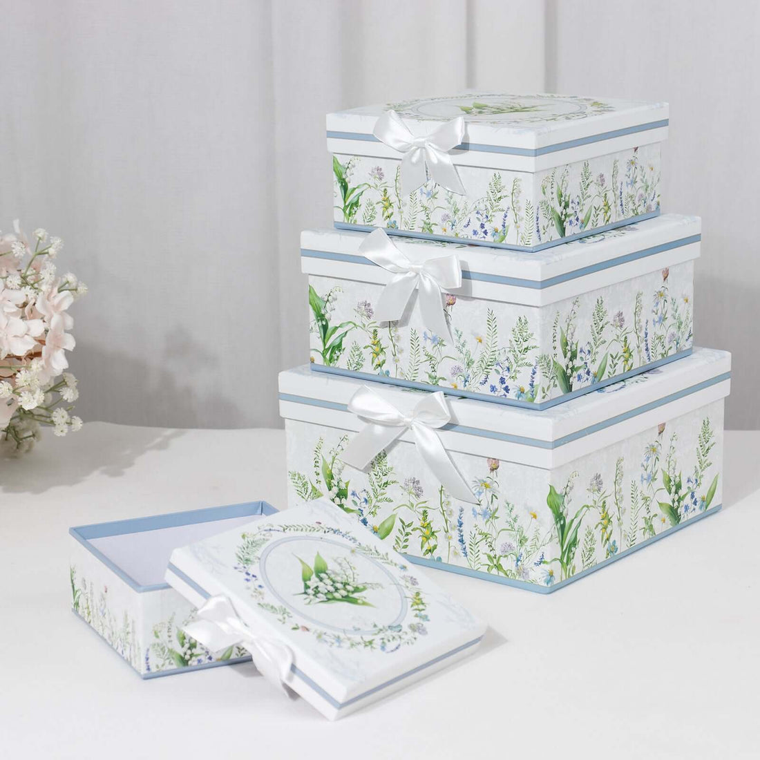 Decorative floral storage boxes stacked with ribbon accents.