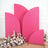 Pink backdrop panels with floral arrangement in a studio setting.