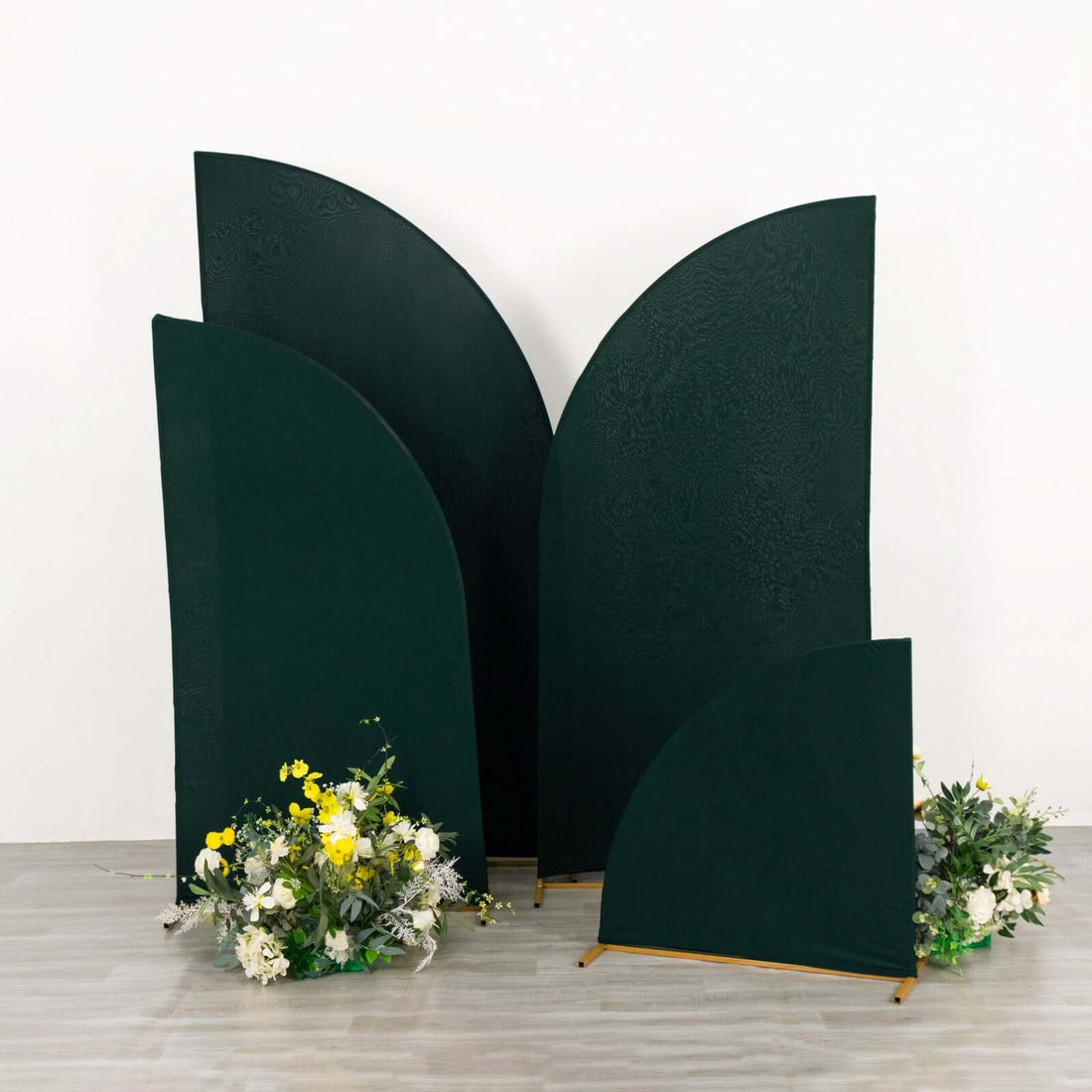 Green decorative panels with floral arrangements in a studio setting.