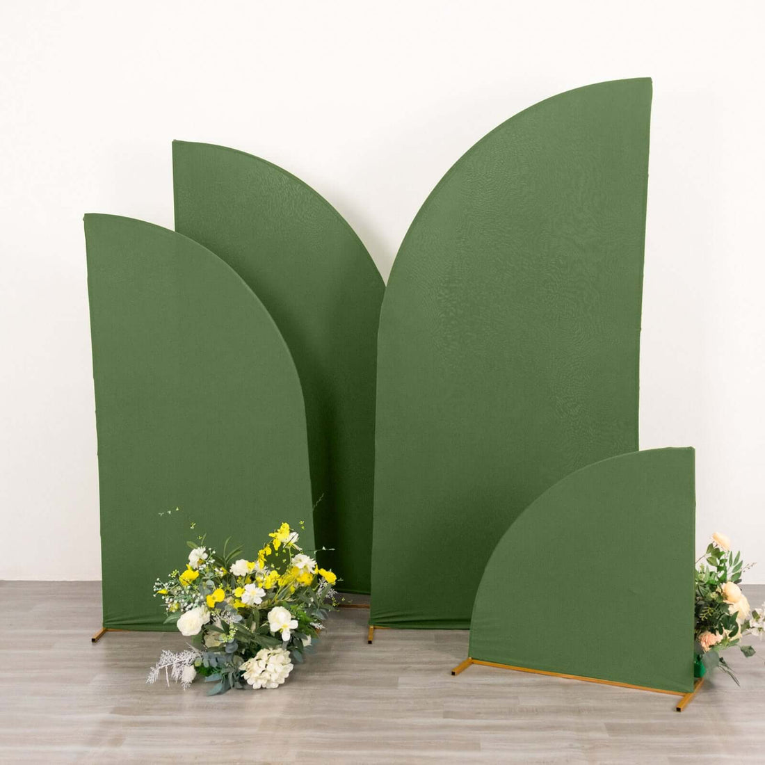 Green curved backdrop panels with floral arrangements in front.