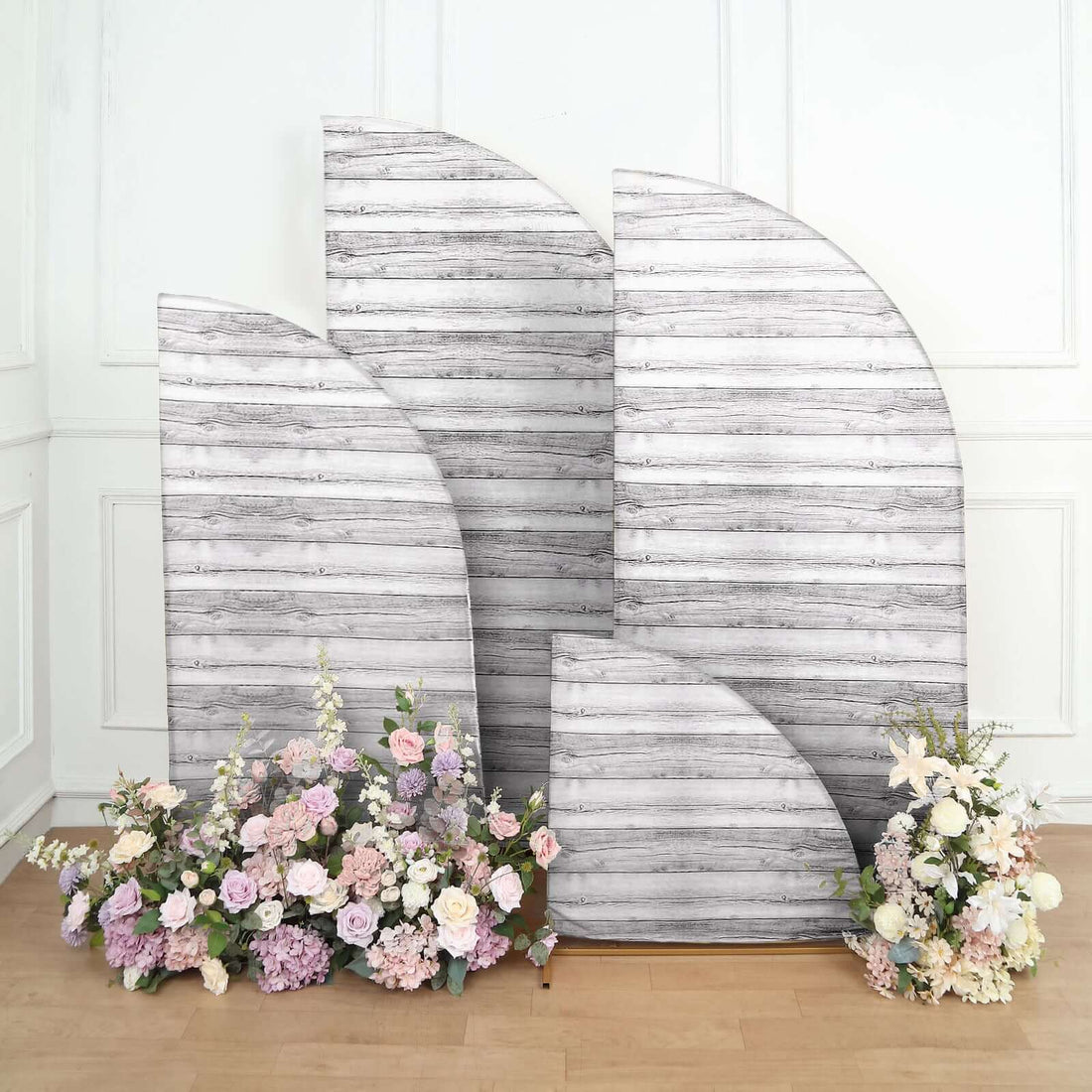 Decorative wooden backdrops with floral arrangements in a studio setting.