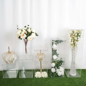 Assorted acrylic display pedestals with floral arrangements and decorative items. #whtbkgd