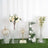 Assorted acrylic display pedestals with floral arrangements and decorative items. #whtbkgd