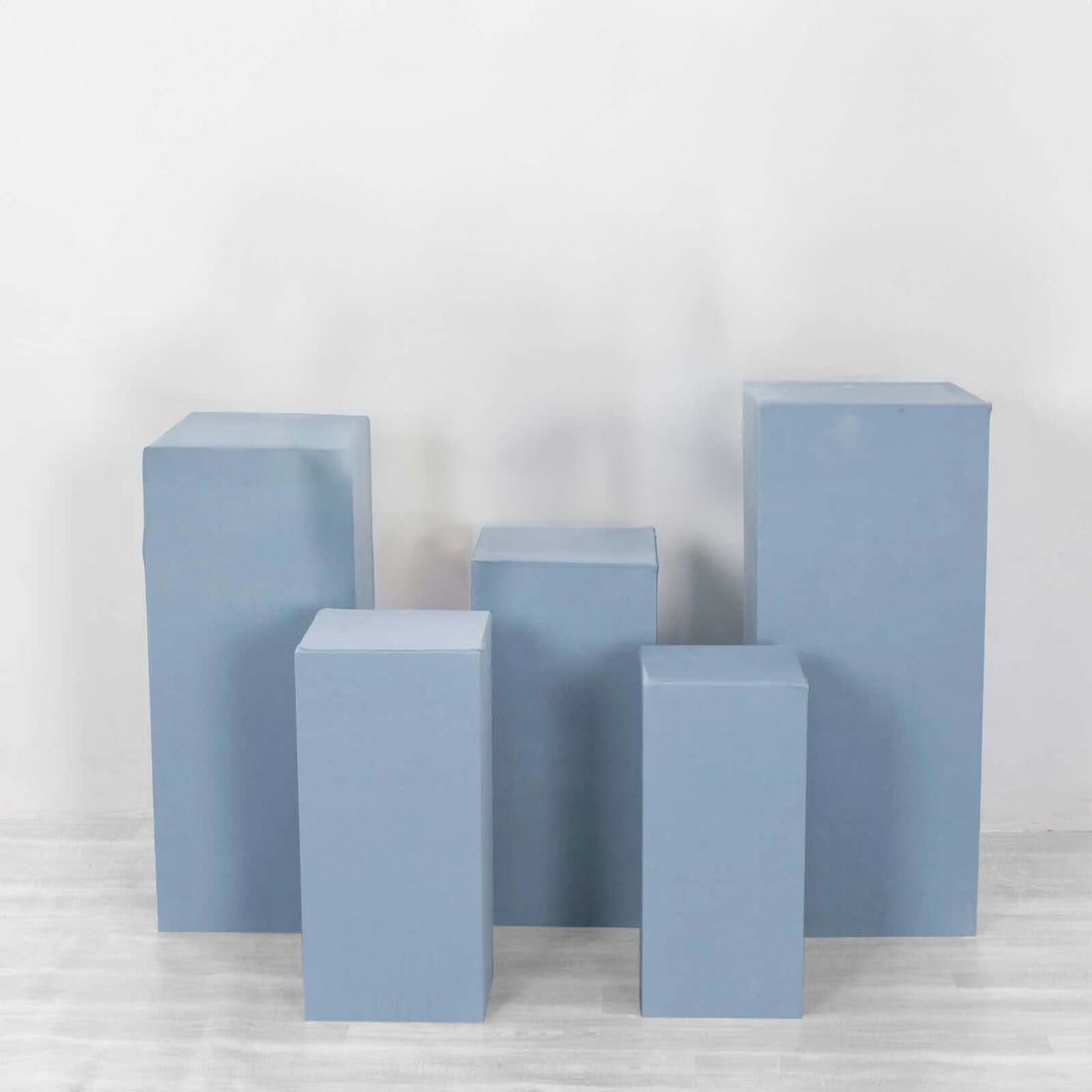 Blue display pedestals of varying heights arranged in a group