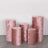 Pink velvet pedestals in various heights on a plain background.
