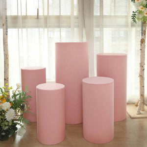 Pink display pedestals in various heights, set against a soft, natural background.