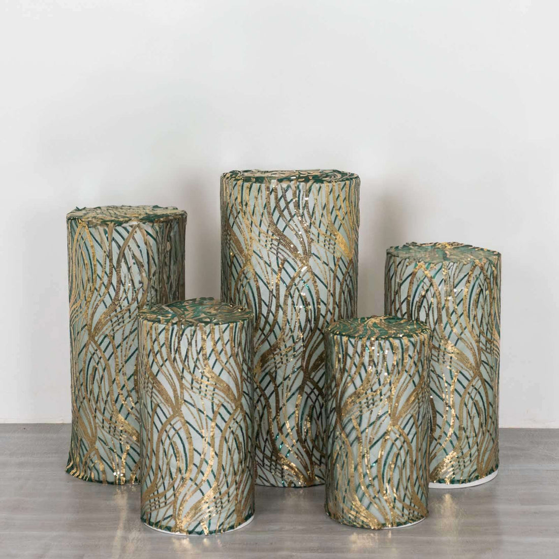 Decorative cylindrical stools with green and gold patterns, arranged in a group.