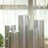Silver display pedestals in a bright, airy room with sheer curtains.