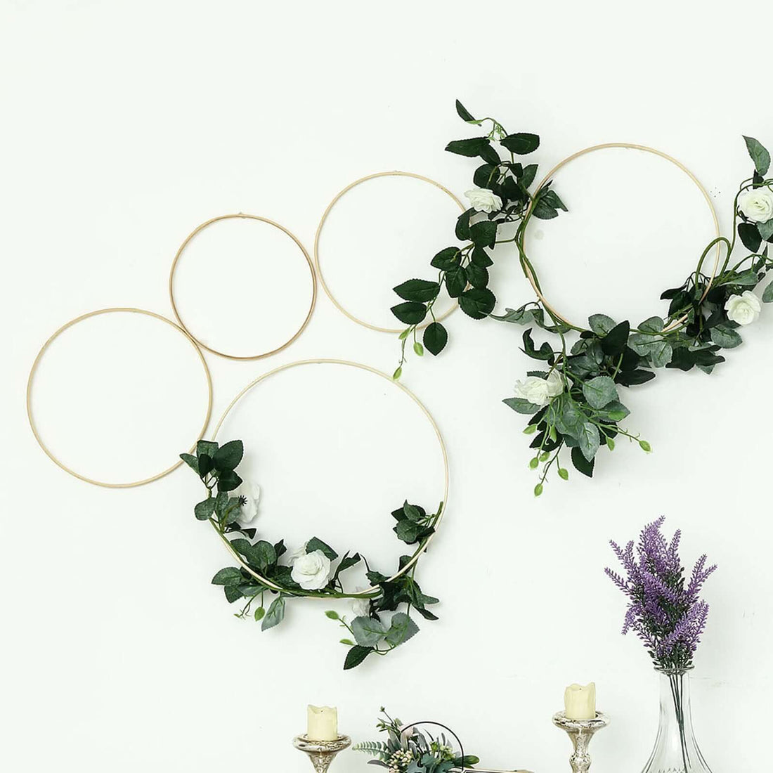 Decorative floral hoops with greenery and flowers on a white wall