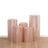 Set of five decorative cylindrical storage containers in pink with metallic accents