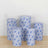 Set of five blue floral-patterned cylindrical stools on a light wooden floor.