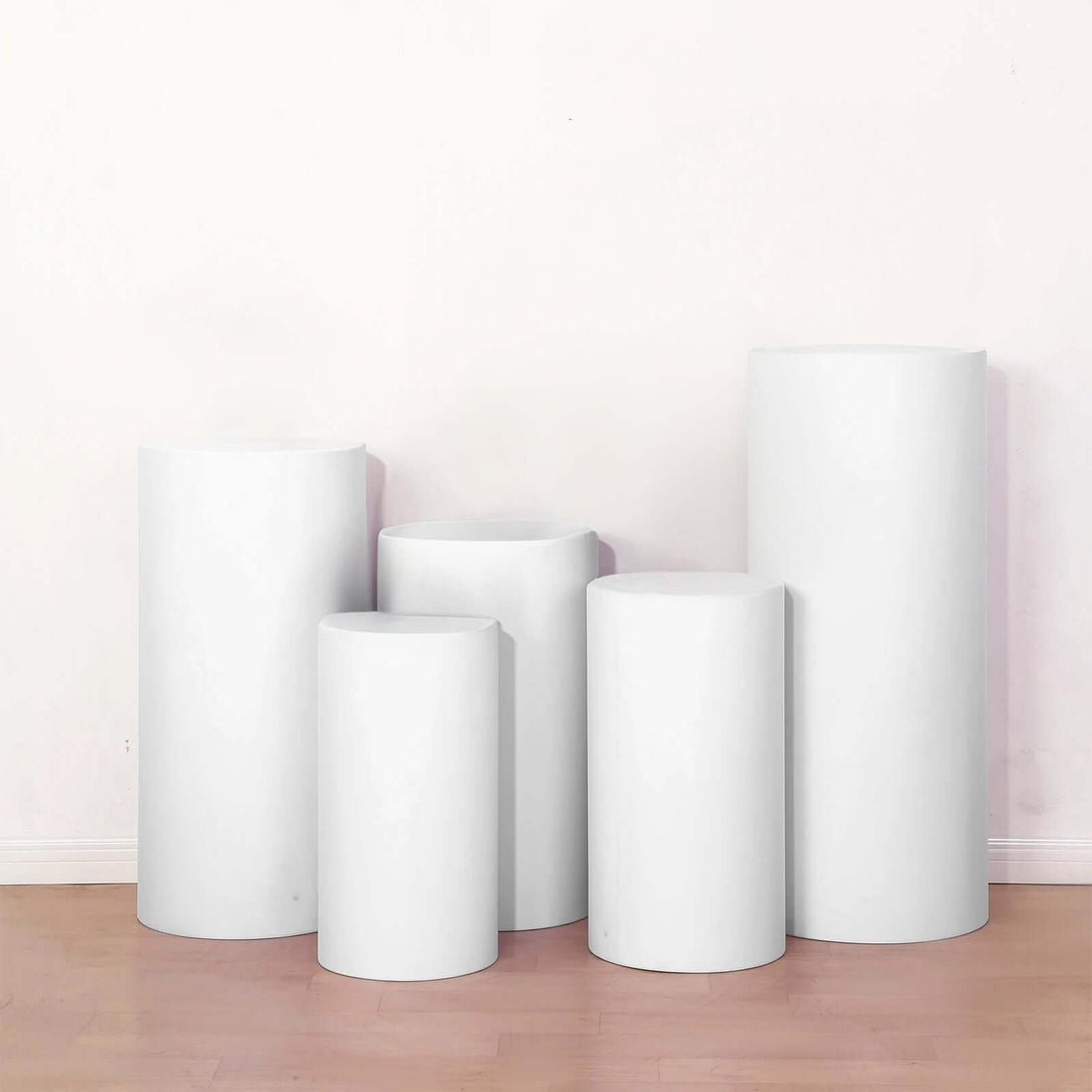 White display pedestals in various heights arranged in a studio setting.