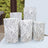 Decorative white and gray textured cylindrical vases in varying heights.