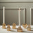Amber glass candle holders with white candles on a neutral surface.