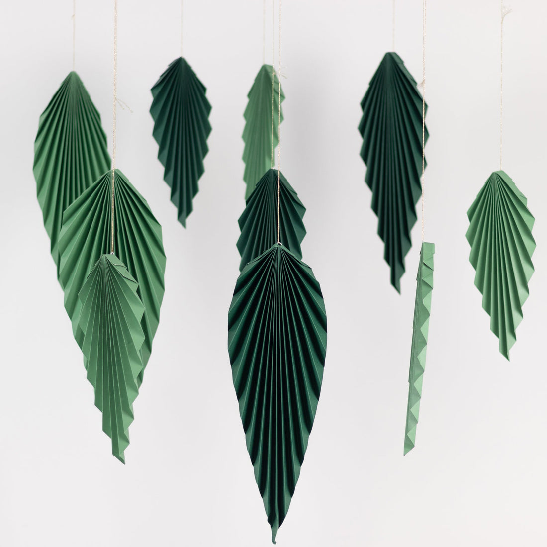 Green paper leaf decorations hanging on strings