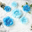 Blue decorative flowers arranged artistically on a white surface.