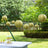 Gold paper lanterns hanging in a garden setting for outdoor decoration.