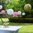 Colorful paper lanterns hanging above a dessert table in a garden setting.