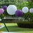 Colorful paper lanterns hanging in a garden setting.